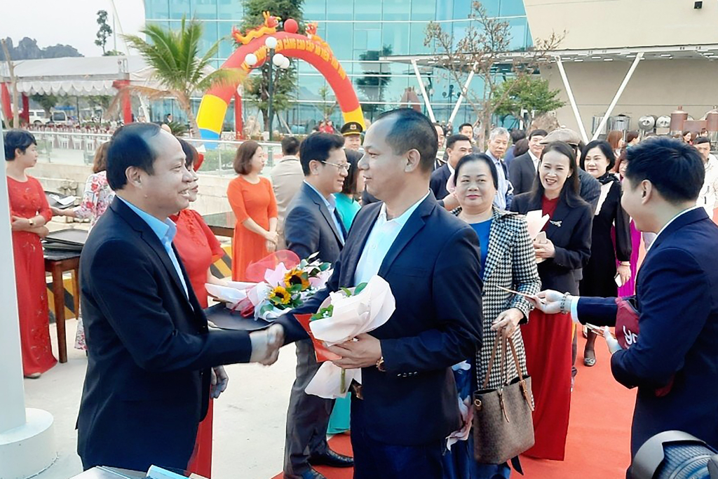 Lãnh đạo huyện Vân Đồn tặng hoa chúc mừng những hành khách đầu tiên tại Cảng cao cấp Ao Tiên. Ảnh: TTTT và VH huyện Vân Đồn cung cấp