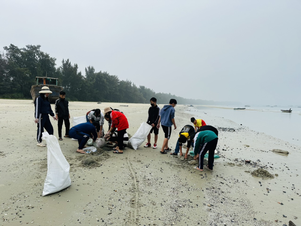 Thầy cô và học sinh thực hiện phong trào “Tiếng trống sạch trường” dọn rác trên bãi biển. 